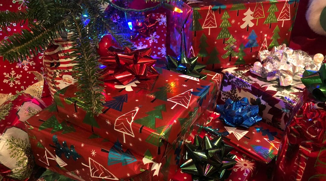 Assorted wrapped Christmas gifts near decorated tree